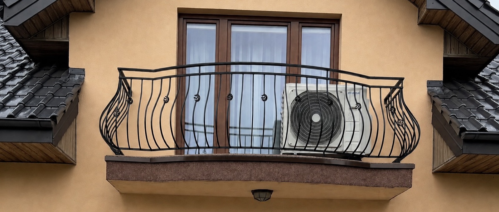 Jednostka zewnętrzna klimatyzacji ukryta za balustradą balkonu na poddaszu